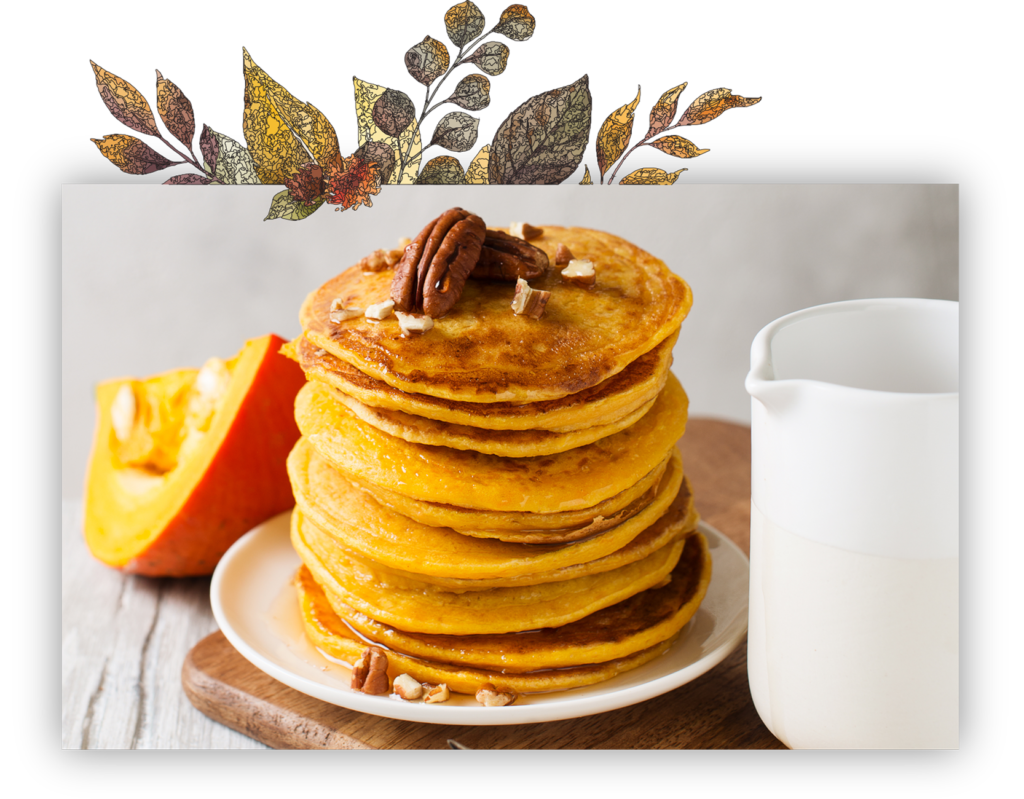 a stack of pancakes with pecans on top next to a pitcher of milk