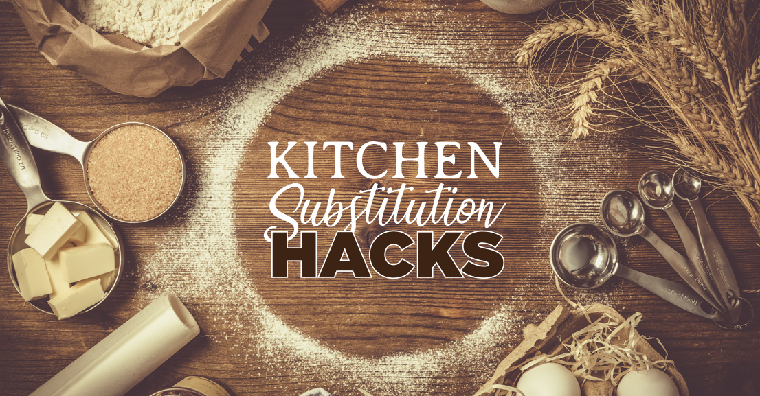 a variety of cooking ingredients like wheat, butter and brown sugar as well as measuring spoons on a wooden table