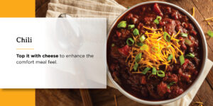 a bowl of chili with cheese and green onions on top