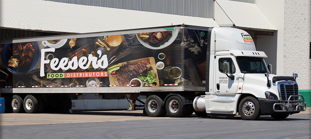 a branded Feeser's 18-wheeler truck with imagery of restaurant meals on it