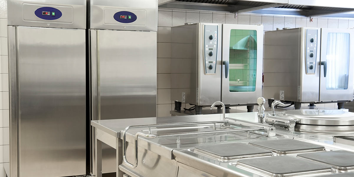 a commercial kitchen with stainless steel appliances and full length fridges