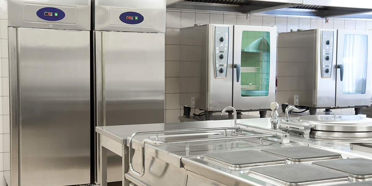commercial kitchen with stainless steel appliances and a large sink area
